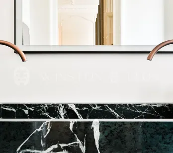 Salle de bain de luxe: double vasque en marbre vert, robinetterie cuivre design. Élégance moderne pour un intérieur raffiné.