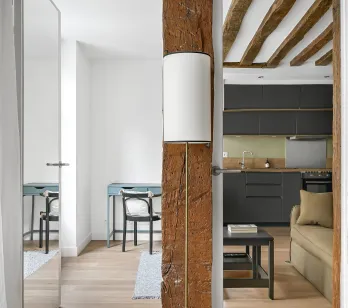 Intérieur de luxe rénové: poutres apparentes, cuisine moderne, design élégant. Charme ancien et confort contemporain.