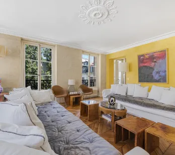 Superbe salon de luxe avec parquet, moulures, grandes fenêtres et design contemporain. Idéal pour un appartement parisien élégant.