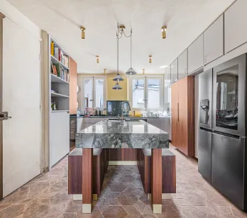 Cuisine de luxe moderne avec îlot central en marbre, électroménager haut de gamme et design élégant. Idéale pour un appartement parisien.