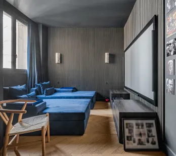 Home cinéma de luxe: banquettes velours bleu, grand écran, murs design. Expérience immersive pour divertissement haut de gamme.