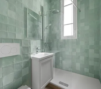 Salle de bain contemporaine avec douche à l'italienne, carrelage vert d'eau lumineux. Design épuré pour un intérieur de luxe moderne.