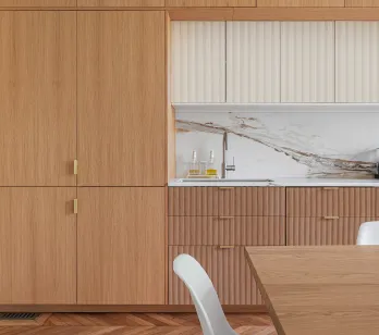 Cuisine design luxe: bois clair, marbre veiné, finitions dorées. Aménagement contemporain avec parquet chevrons et électroménager Smeg.