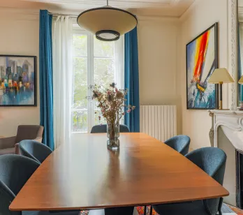 Salle à manger élégante et lumineuse, design moderne et touches artistiques. Un espace raffiné avec cheminée pour propriété de luxe.