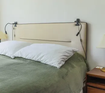 Chambre de luxe moderne. Lit douillet, tête de lit design, éclairage intégré, table de chevet élégante. Espace serein pour un repos optimal.