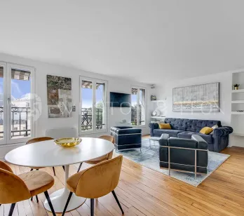 Appartement de luxe lumineux avec salon/salle à manger moderne, parquet, grandes fenêtres et vue ville. Design élégant et contemporain.