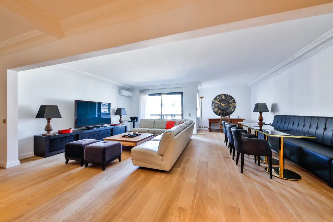 Salon et salle à manger modernes et lumineux avec parquet, mobilier design et TV grand écran. Idéal pour un appartement de luxe.