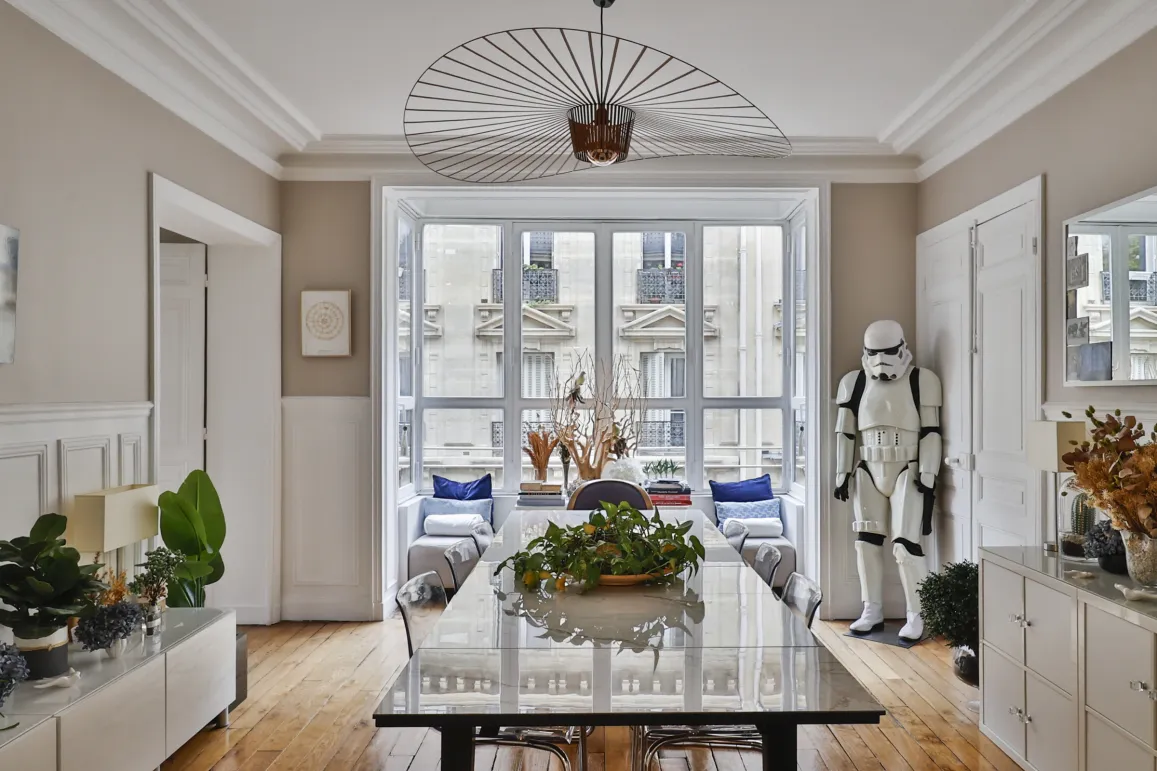 Salle à manger de luxe parisienne, design moderne et lumineux. Décoration élégante avec touche d'originalité. Vue urbaine, appartement de prestige.