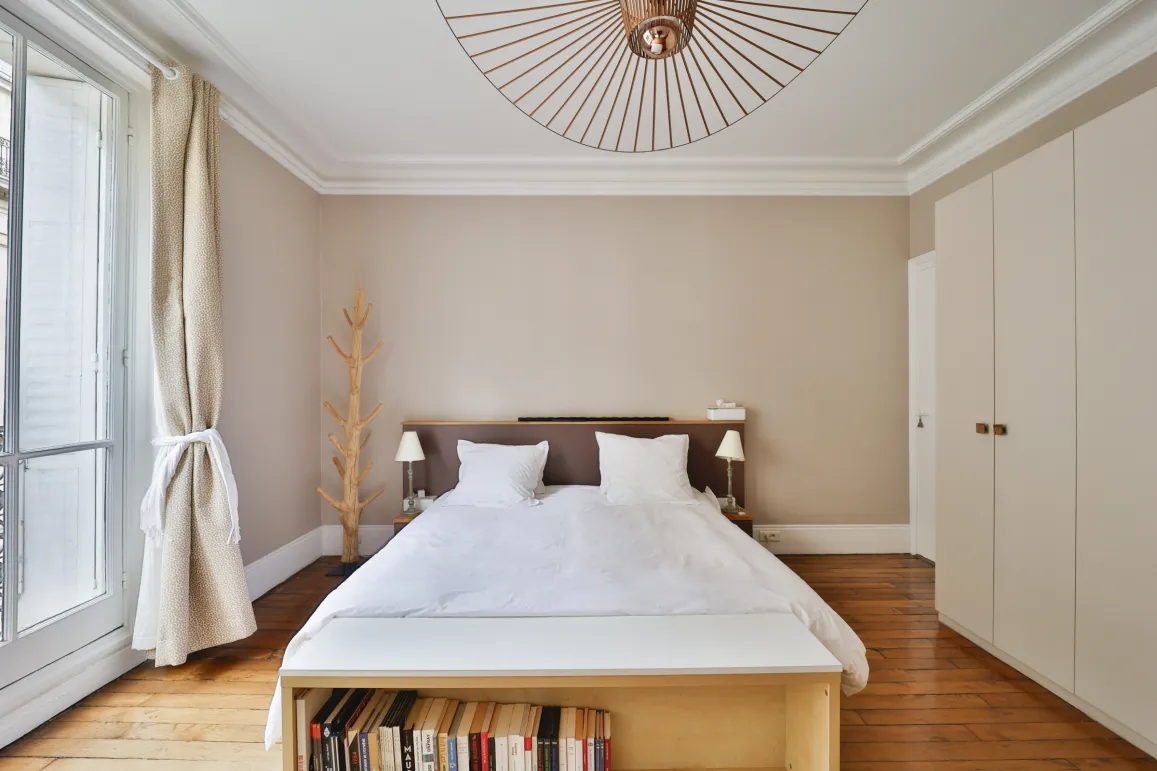 Chambre de luxe lumineuse avec parquet, design moderne et épuré. Idéale pour un appartement parisien élégant et confortable.