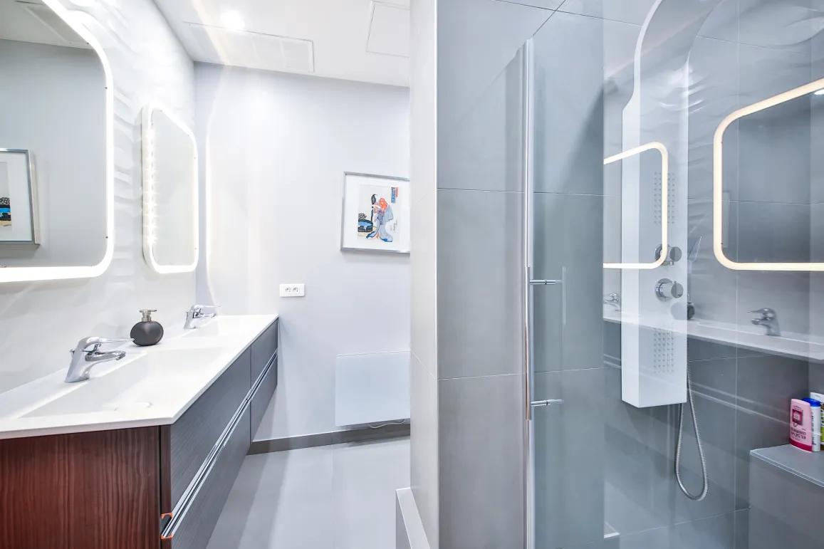 Salle de bain luxe moderne avec double vasque, miroirs LED et douche vitrée. Design épuré, finitions haut de gamme pour propriété exclusive.