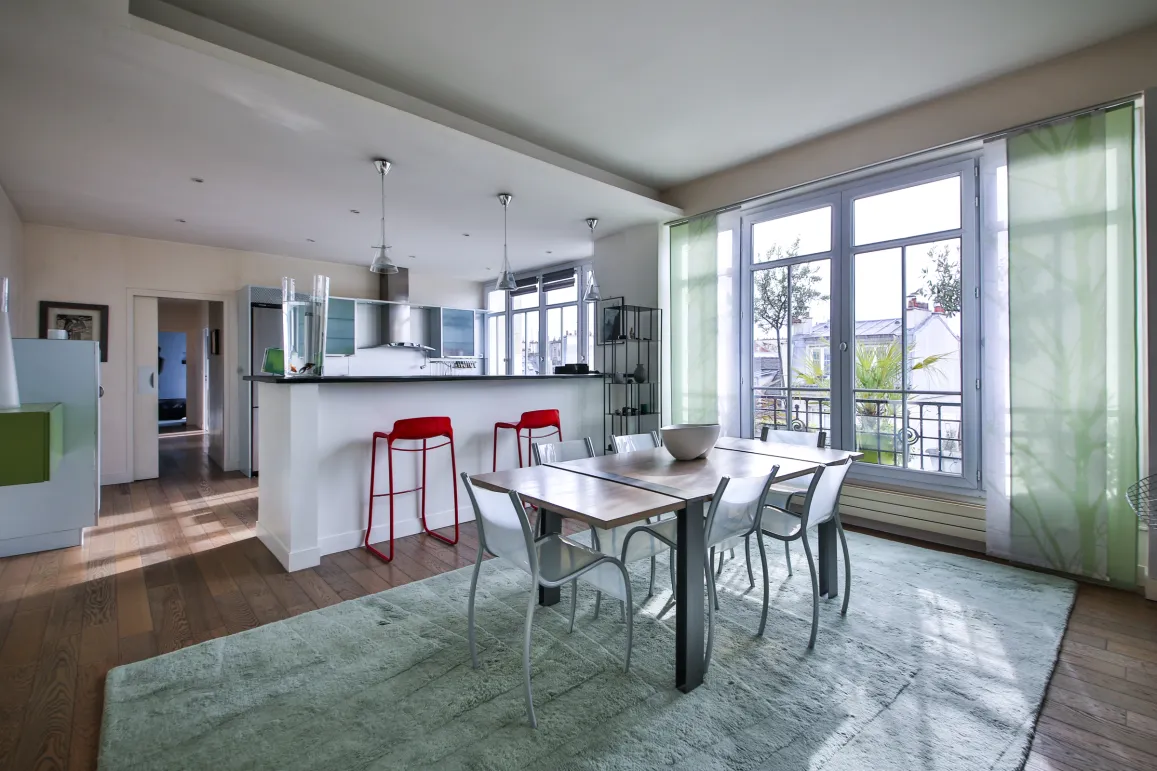 Appartement de luxe moderne avec cuisine ouverte, salle à manger lumineuse et vue. Design contemporain, parquet et grandes fenêtres.