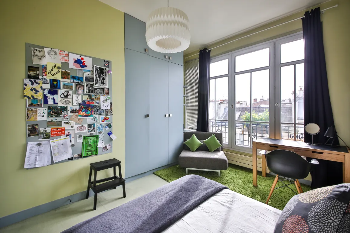 Chambre de luxe moderne, lumineuse, vue ville. Design contemporain, bureau, rangements intégrés. Idéal appartement urbain.