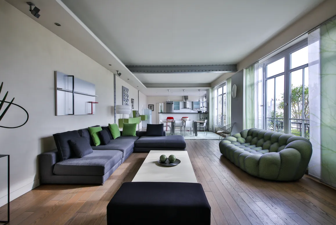Salon moderne luxe avec canapés design, parquet, cuisine ouverte. Appartement spacieux et lumineux pour vie contemporaine.