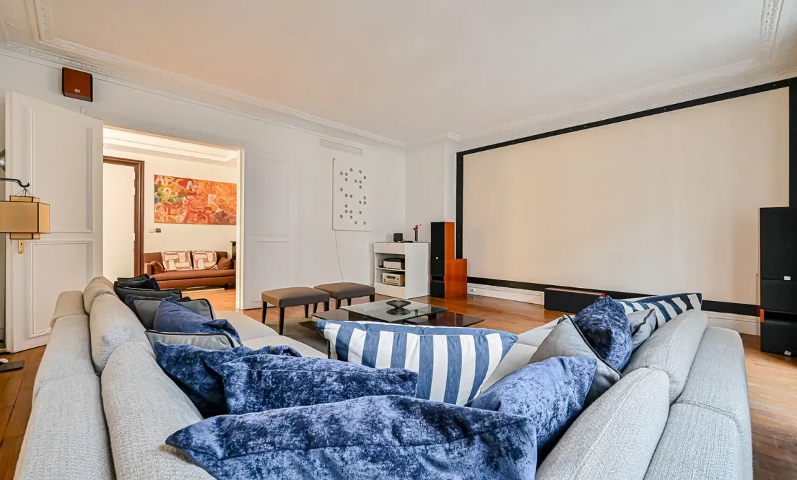 Salon de luxe moderne avec home cinéma intégré, canapé design et ambiance raffinée. Idéal pour divertissement haut de gamme.