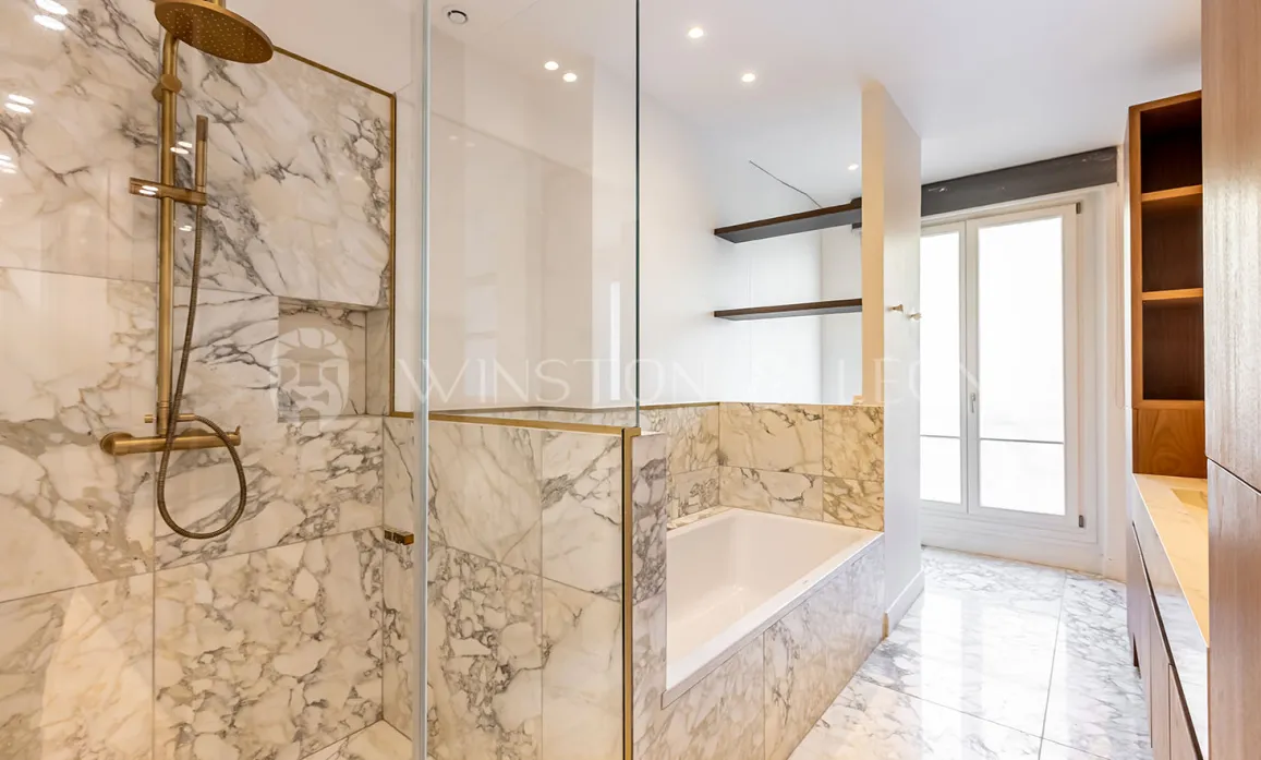 Salle de bain luxe marbre, douche italienne, baignoire, robinetterie dorée. Design moderne et élégant pour propriété de prestige.