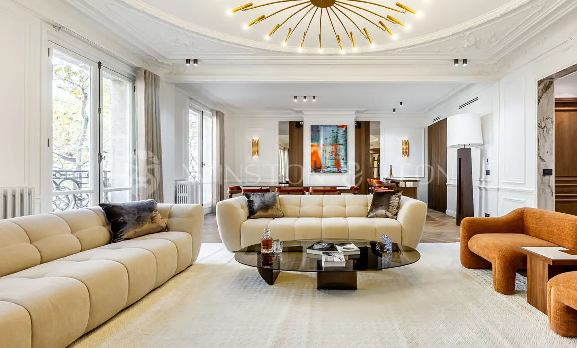 Salon de luxe contemporain avec mobilier design, plafonds hauts, grandes fenêtres et œuvres d'art. Élégance et confort pour un intérieur d'exception.