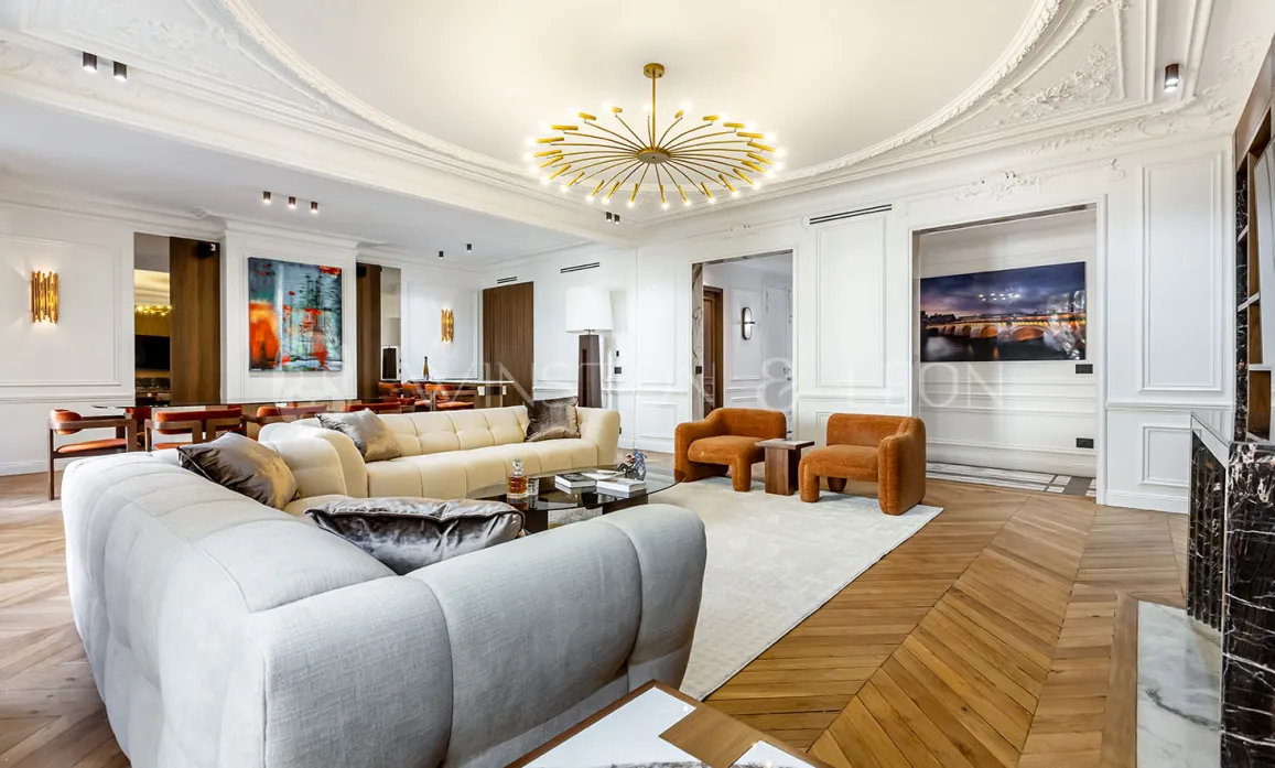 Sublime salon d'appartement de luxe parisien. Ambiance haussmannienne modernisée, mobilier design, parquet, moulures, lustre contemporain.