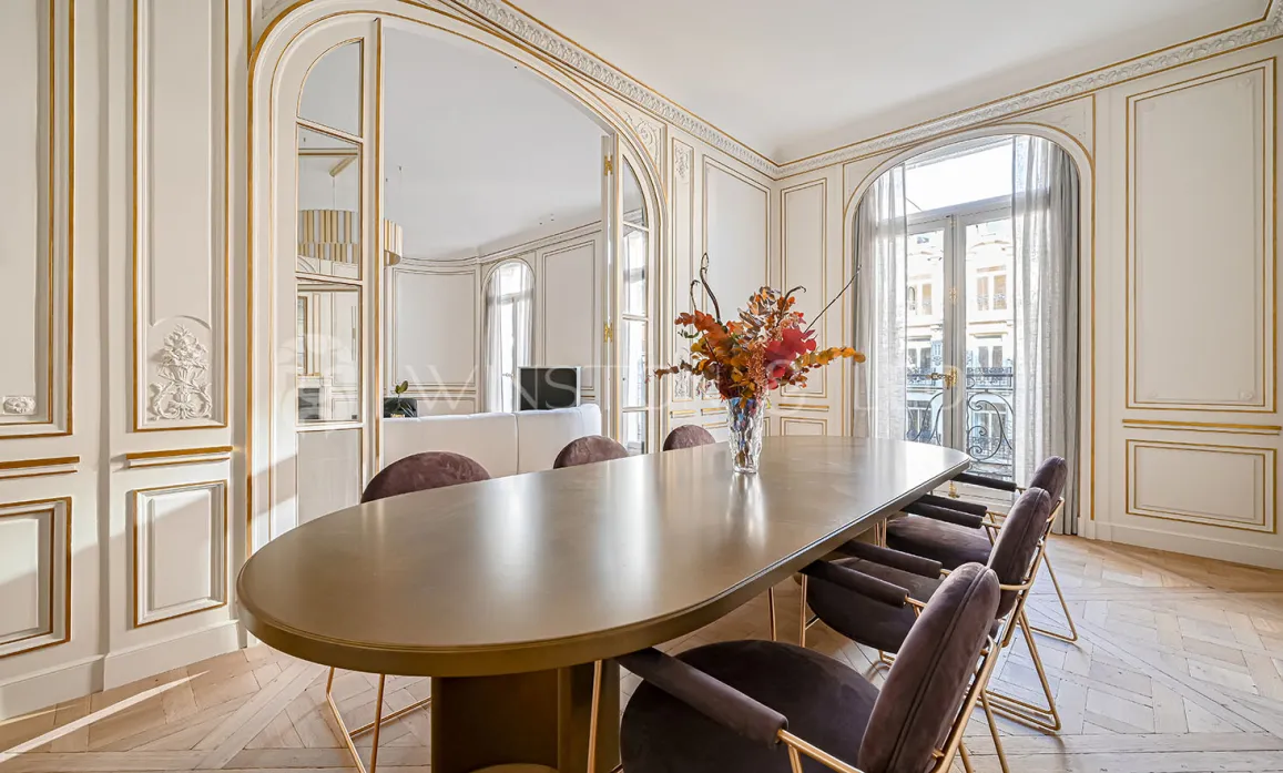 Salle à manger de luxe parisienne: moulures dorées, parquet, design contemporain. Élégance et prestige pour un appartement d'exception.