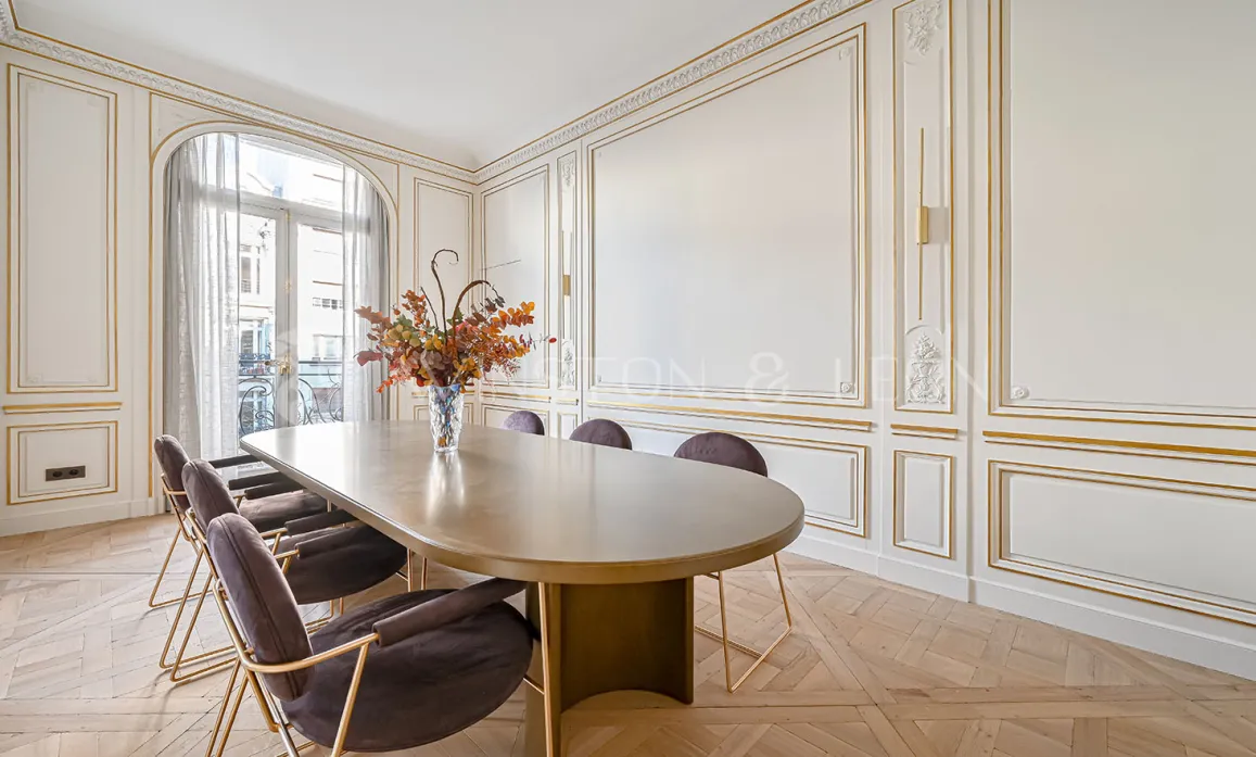 Salle à manger de prestige à Paris, moulures or, parquet point de Hongrie, mobilier design. Luxe et raffinement.