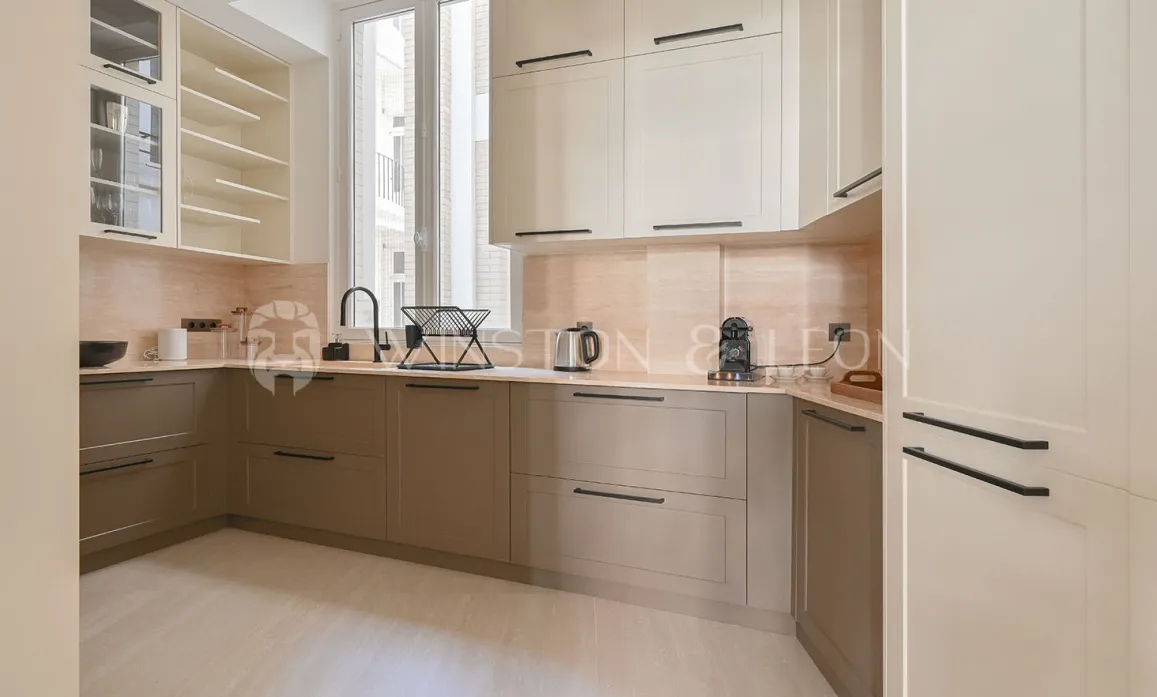 Cuisine de luxe moderne bicolore (beige/taupe), design épuré, finitions haut de gamme. Idéale pour un appartement contemporain.