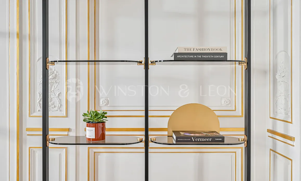 Étagère design luxe en verre et métal noir, accents or, sur fond de boiseries classiques haussmanniennes. Élégance et raffinement contemporain.