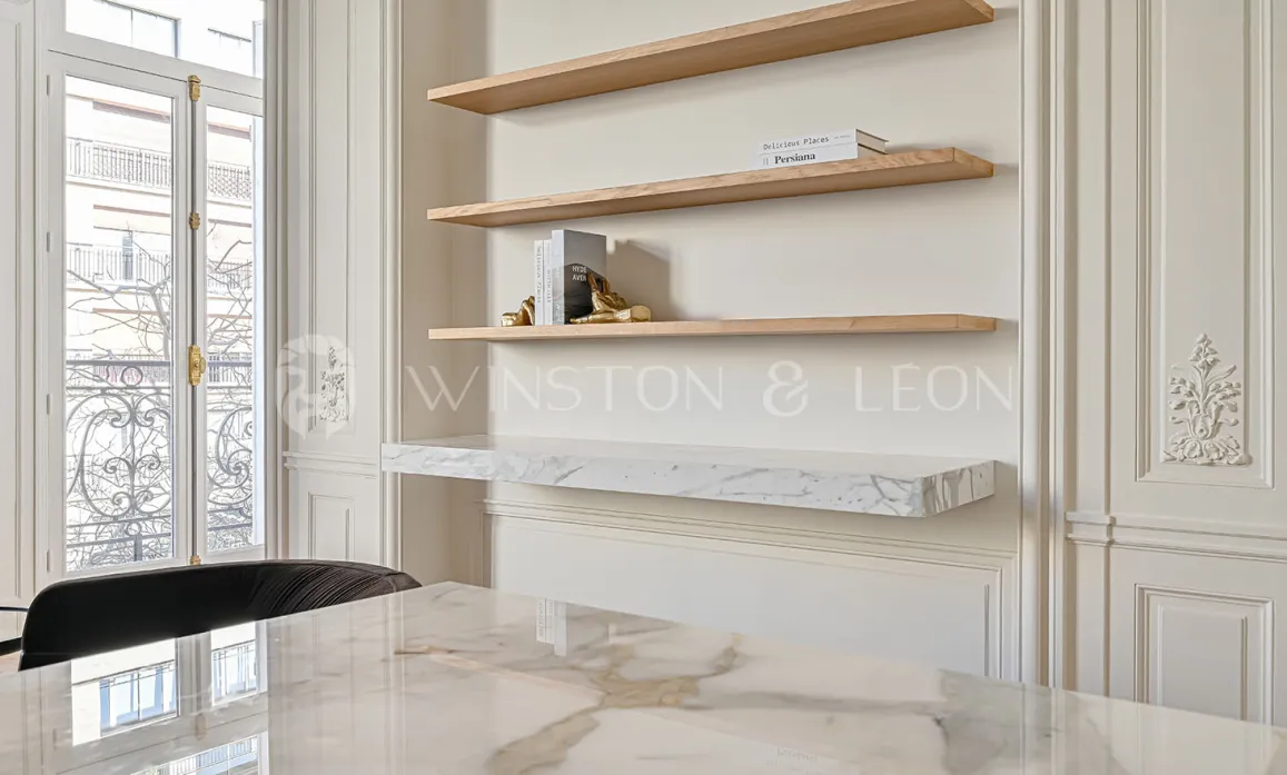 Sublime design intérieur luxe: table marbre, étagères bois, boiseries élégantes, fenêtre haussmannienne. Raffinement et luminosité pour propriété d'exception.