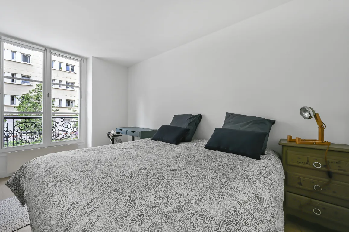 Suite parentale lumineuse, design épuré, vue urbaine, balcon fer forgé. Confort et élégance pour votre appartement de luxe.