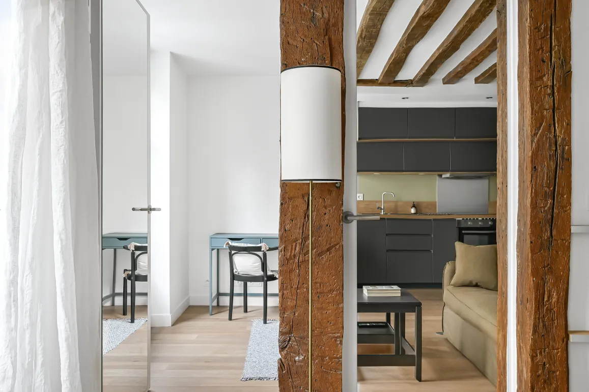 Intérieur de luxe rénové: poutres apparentes, cuisine moderne, design élégant. Charme ancien et confort contemporain.