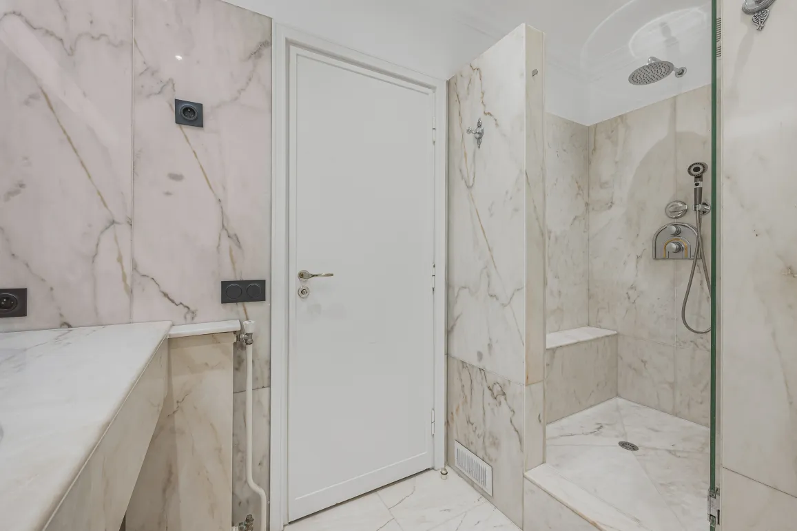 Salle de bain de luxe en marbre, douche italienne moderne et élégante. Design contemporain pour un bien immobilier haut de gamme.