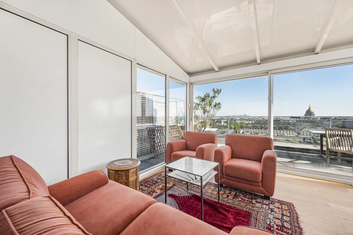 Penthouse de luxe à Paris avec vue panoramique sur les Invalides et terrasse ensoleillée. Salon élégant et lumineux.