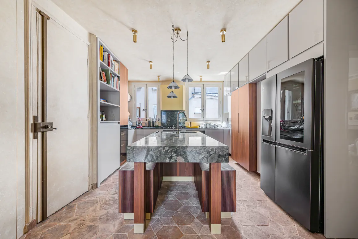 Cuisine de luxe moderne avec îlot central en marbre, électroménager haut de gamme et design élégant. Idéale pour un appartement parisien.