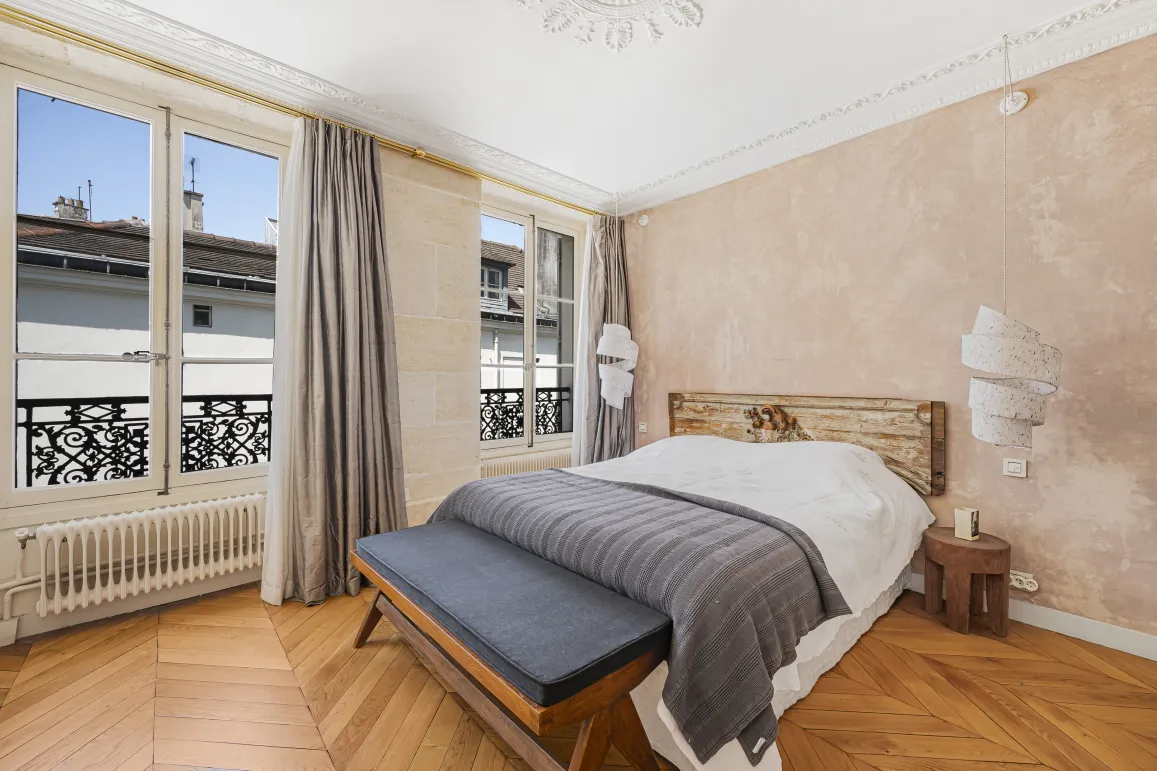 Chambre de luxe parisienne. Parquet, vue sur la ville, design élégant et confortable. Ambiance raffinée.