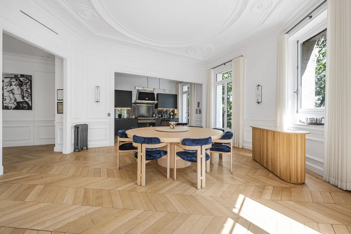 Appartement de luxe lumineux avec salle à manger contemporaine, cuisine ouverte moderne et parquet chevron. Design élégant et spacieux.
