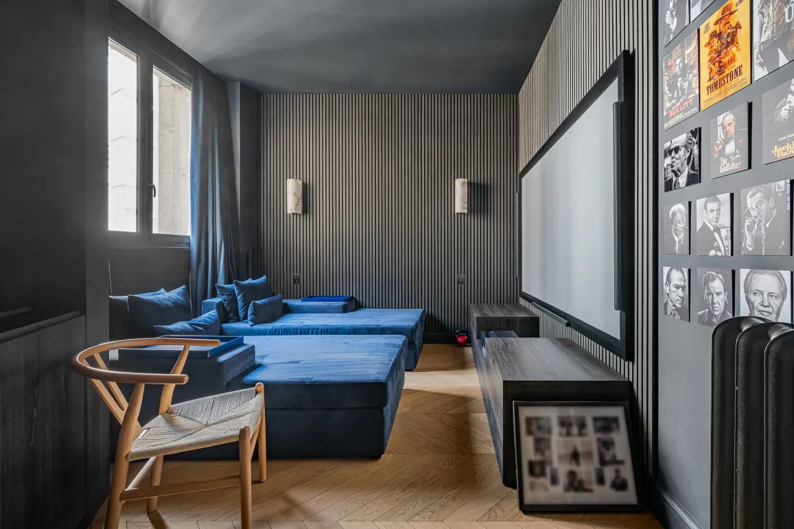 Home cinéma de luxe: banquettes velours bleu, grand écran, murs design. Expérience immersive pour divertissement haut de gamme.