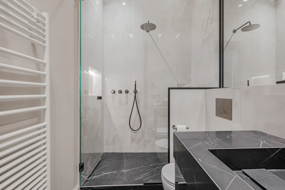 Salle de bain de luxe moderne: douche à l'italienne marbre noir & blanc, vasque design, sèche-serviettes. Élégance et confort.