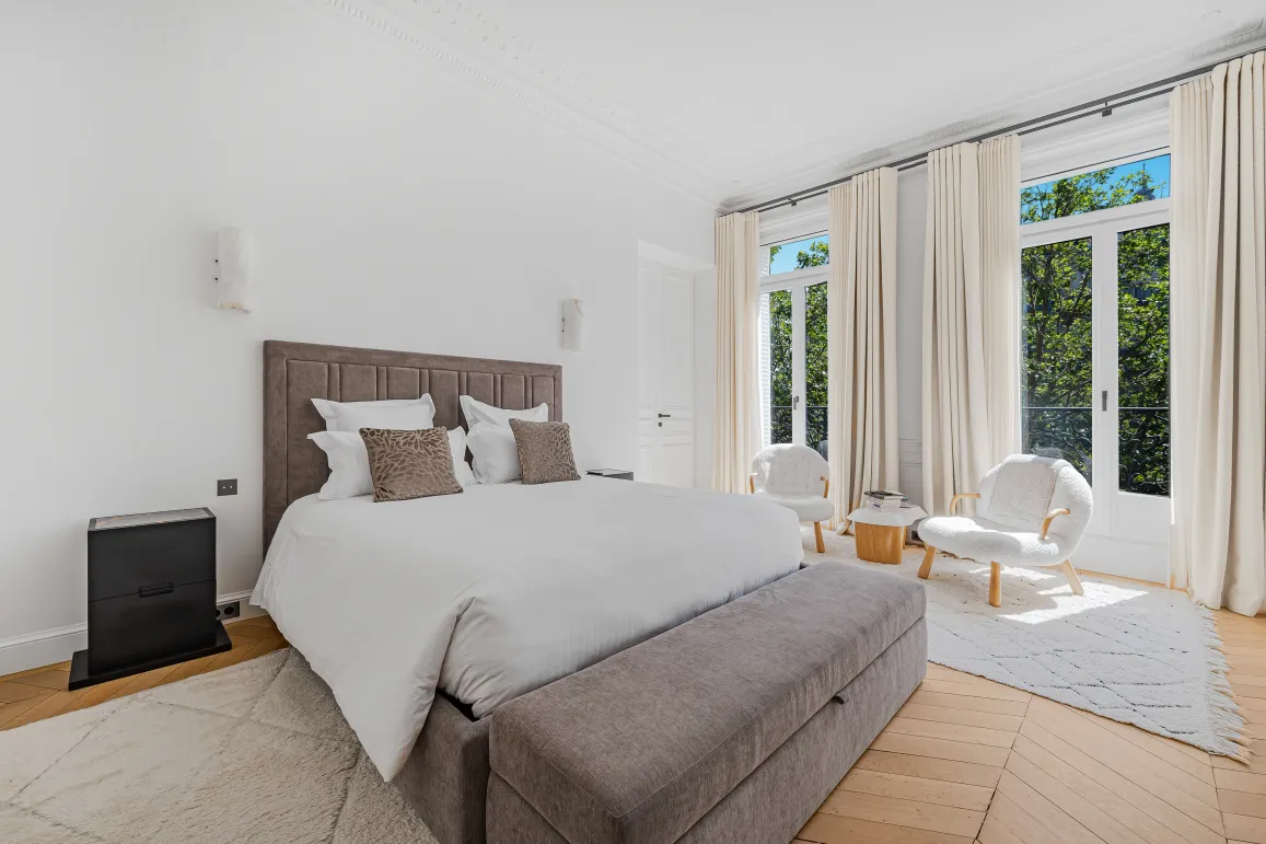 Chambre de maître luxueuse, design épuré, vue verdoyante. Confort et élégance pour un immobilier de prestige. Appartement haut standing.
