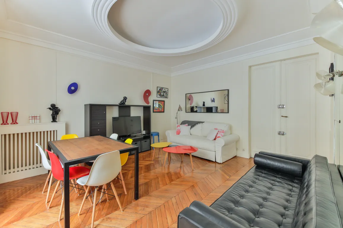 Luxueux salon-salle à manger moderne. Parquet, mobilier design coloré, espace lumineux. Idéal pour un appartement de prestige.