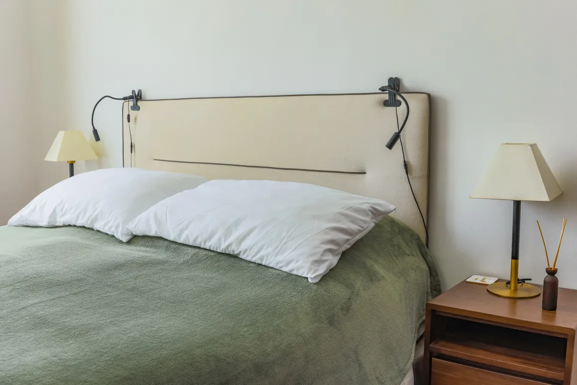 Chambre de luxe moderne. Lit douillet, tête de lit design, éclairage intégré, table de chevet élégante. Espace serein pour un repos optimal.