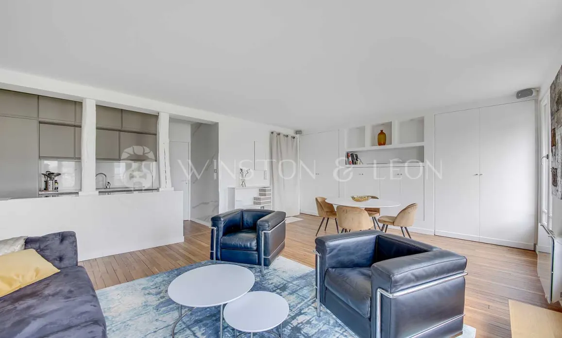 Salon-salle à manger ouvert et lumineux avec cuisine moderne intégrée. Mobilier design, ambiance contemporaine et raffinée pour un appartement de luxe.