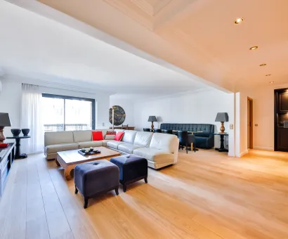 Salon de luxe spacieux et lumineux avec parquet clair, canapé sectionnel moderne, coin repas et bar intégré. Design contemporain haut de gamme.