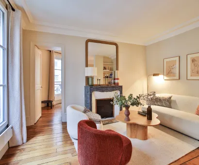 Salon parisien luxe, design moderne et élégant avec cheminée, parquet et lumière naturelle. Idéal pour un appartement haut de gamme.