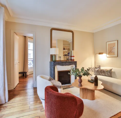 Salon parisien luxe, design moderne et élégant avec cheminée, parquet et lumière naturelle. Idéal pour un appartement haut de gamme.